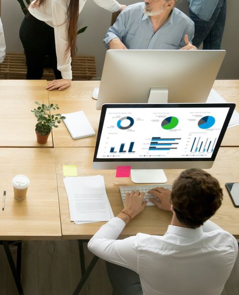 A man using EXOS One Marketplace on his desktop computer in an office 